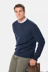 Buzo tejido de lana con escote redondo a la base y mangas largas. Presenta un diseño clásico con puños y ruedo acanalados, y un pequeño logo bordado en el pecho.