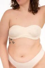 Soutien strapless color beige con aro y copas moldeadas, confeccionado en lycra reforzada doble. Cuenta con diseño de efecto segunda piel y broches reforzados en la espalda.