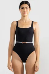 Traje de baño entero negro con textura acanalada y cinturón blanco con hebilla metálica.