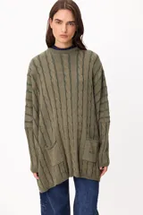 Sweater de tejido artesanal con diseño de rayas verticales en tonos camel y beige, corte holgado, cuello redondo y puños altos ajustados.