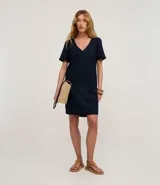 Vestido corto tipo t-shirt de la marca Marfinno, confeccionado en viscolino. Presenta escote en V, mangas cortas y bolsillos laterales aplicados. Su diseño es holgado y fluido.