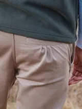 Pantalón de vestir azul marino, de corte recto, con bolsillos laterales y traseros. Se ajusta a la cintura con cinturón de cuero marrón.