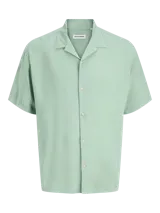 Camisa de manga corta color verde menta, con cuello cubano y cierre frontal con botones.