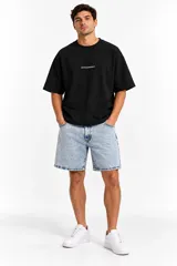 Bermuda slouchy de denim en tono celeste claro, con diseño clásico de cinco bolsillos, trabillas para cinturón y cierre frontal con botón y cremallera.
