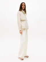 Zapatillas de estilo running con exterior de punto elástico color beige, diseño de corte bajo con ajuste estilo calcetín y cierre de cordones. Presenta el logo de Tommy Hilfiger bordado en el lateral y suela de goma blanca.