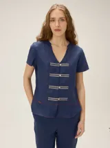 Camisa azul marino de lino, de corte holgado y manga corta, con cuello en V y detalles de galones decorativos con botones frontales.