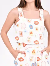 Musculosa de corte recto con escote cuadrado y breteles anchos, confeccionada en tela blanca con estampado de etiquetas de frutas coloridas.