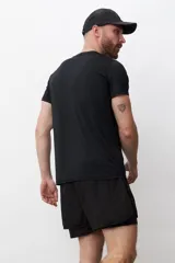 Remera deportiva negra de poliéster con tecnología dry fit y logo pequeño en el pecho.