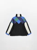 Campera con cierre frontal y cuello alto, confeccionada en fleece color crudo, con paneles en rojo, marrón y bordó.