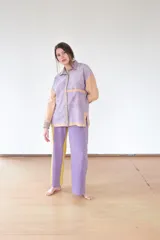 Pantalón de jersey de lana merino color lila y amarillo, de tiro medio y silueta holgada. Se ajusta con un cinturón del mismo tejido que se ata en la espalda.