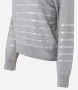 Suéter de punto color negro con cuello redondo y mangas largas. Presenta un diseño con franjas horizontales decoradas con lentejuelas del mismo tono en el cuerpo y las mangas.