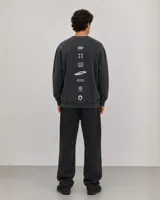 Buzo de cuello redondo con diseño oversize, confeccionado en algodón con efecto lavado. Presenta detalles gráficos estampados en el pecho y etiqueta decorativa en el ruedo.