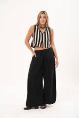 Pantalón negro de pierna súper amplia, confeccionado en denim fino y liviano con caída fluida. Tiene cintura elastizada con lazo regulable, bolsillos laterales y pinzas en la delantera.