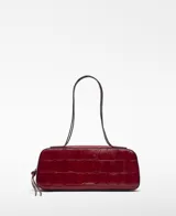 Bolso tipo bowling Mica de piel bovina, color rojo oscuro, con grabado efecto cocodrilo. Presenta un compartimento principal con cierre de cremallera, bolsillo interior con cierre y asas de hombro.