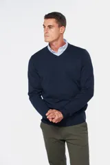 Suéter de tejido fino color azul marino, con cuello en V y manga larga. Presenta un pequeño logo bordado en el pecho.