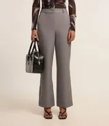 Pantalón de vestir gris oscuro, de corte recto, con bolsillos laterales y traseros. Se ajusta a la cintura con cinturón de cuero marrón.