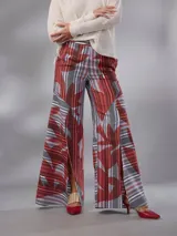 Pantalón de cintura alta y piernas amplias en lino mezcla, con estampado vegetal en tonos bordó, gris y blanco, y tajos asimétricos en las piernas. Cuenta con cierre invisible lateral y bolsillos.