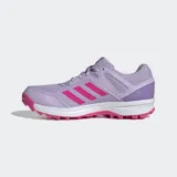 Championes de hockey Adidas Fabela Rise para mujer, color violeta con las tres tiras características en fucsia. Presentan un diseño con exterior de malla transpirable, refuerzos sintéticos para mayor soporte, mediasuela de EVA para amortiguación y suela Traxion con tapones para un agarre óptimo en la cancha.