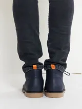 Botas de cuero azul marino con cordones y suela de goma en tono tostado.