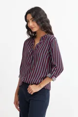 Blusa de viscosa con estampado de rayas verticales en azul marino, rojo y blanco, con cuello mao y mangas largas con puños abotonados.