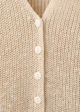 Chaleco de punto grueso color beige, con diseño recto, escote en V con solapa, sin mangas, tirantes anchos y cierre delantero con botones.