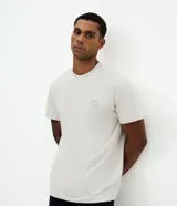 Remera de algodón con cuello redondo y manga corta, de corte holgado y diseño minimalista con un pequeño sello náutico estampado en el pecho.
