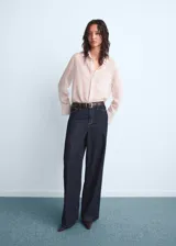 Jean de tiro medio con diseño wide leg, confeccionado en tejido de algodón estilo vaquero. Cuenta con cinco bolsillos y cierre frontal oculto con botón, gancho y cremallera.