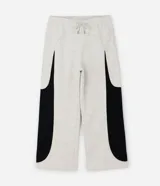 Pantalón de jogging confeccionado en algodón y poliéster, con diseño de paneles laterales en contraste de color negro. Presenta cintura elástica con cordón ajustable y bolsillos laterales.