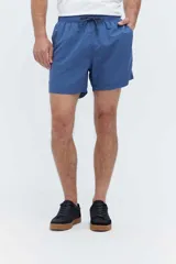 Short de baño azul, de corte clásico y largo corto, con cintura elástica y cordón ajustable bicolor. Cuenta con bolsillos laterales y uno trasero.