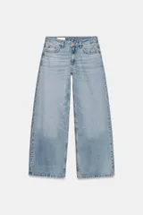 Jeans de tiro alto con diseño de pierna ancha y corte extra largo. Presenta cinco bolsillos clásicos y detalle de tachas metálicas a lo largo de las costuras laterales. Cierre frontal con cremallera y botón metálico.