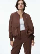 Campera deportiva color bordó con cuello tipo bomber, cierre frontal completo y mangas raglán. Presenta puños, cuello y ruedo acanalados, además de bolsillos frontales.
