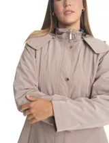 Gabardina impermeable de alta densidad color beige, con capucha desmontable, cierre metálico oculto bajo cartera con botones a presión dorados y forro interno desmontable.