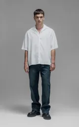 Camisa de manga corta con cuello cubano, corte oversize y cierre frontal de botones. Confeccionada en tejido de lyocell, presenta un diseño minimalista y liso.