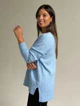 Sweater de punto color celeste, con cuello en V, mangas largas con puños acanalados y detalle de costura vertical central.