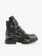 Bota corta de cuero bovino con efecto desgastado y envejecido en tonos negro y gris. Presenta caña arrugada, cierre lateral y una correa ancha con hebilla metálica. La suela es gruesa y dentada, con efecto plataforma.