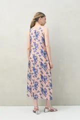 Vestido largo sin mangas de silueta fluida, color rosado con estampado floral abstracto en azul.