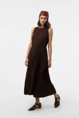 Vestido midi sin mangas de color marrón, confeccionado con textura arrugada, escote redondo, silueta relajada y caída liviana, con un lazo fino ajustable en la cintura.