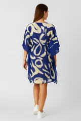 Tunica de algodón con estampado abstracto en tonos azul y blanco. Presenta cuello en V, mangas cortas amplias y ajuste con cordón en la cintura.