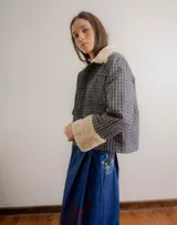 Chaqueta de jacquard con diseño a cuadros, cuello y puños de piel sintética, cierre frontal y bolsillos laterales.