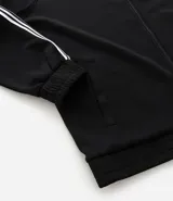 Campera deportiva de cuello alto con cierre frontal completo, mangas largas con rayas laterales blancas contrastantes y bolsillos laterales. Presenta un bordado pequeño en el pecho.