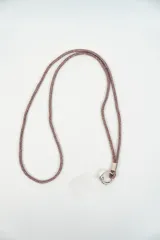 Correa para celular con diseño de cordón brillante en tono plateado, cuenta con un gancho metálico circular para sujetar el dispositivo.