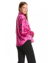 Camisa de satén con estampado de rectángulos negros sobre fondo blanco. Presenta cuello clásico con solapa, cierre frontal con botones metálicos y mangas largas con puños rectos.