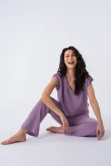 Remera lila de tejido de punto, con cuello en V y corte holgado estilo musculosa con hombros caídos.