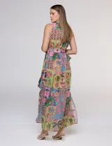 Vestido largo sin mangas de gasa color rosa, con estampado tipo patchwork tropical que incluye piñas, flamencos y motivos botánicos. Cuenta con un pronunciado escote en V y cintura elastizada.