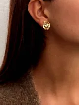 Par de aros dorados con forma de corazón sagrado con llamas y rayos. Cierre a presión.