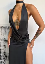 Vestido largo negro con escote halter profundo, diseño cruzado en la cintura y tajo lateral pronunciado en la falda.