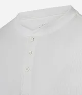 Remera masculina blanca de manga corta, con cuello redondo y abertura frontal con botones. Confeccionada en algodón y poliéster con textura, de corte ajustado.
