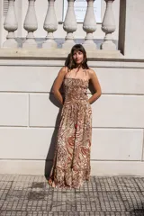 Vestido largo de silueta fluida con estampado animal print en tonos tierra. Presenta un top fruncido con tiras finas, espalda descubierta y falda amplia con volado en el ruedo.