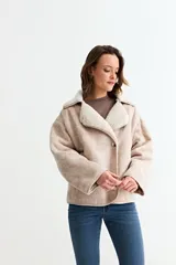Chaqueta de simil gamuza en color beige, con forro interno y cuello de corderito sintético. Presenta un diseño de corte holgado, cierre frontal con botones y bolsillos laterales.