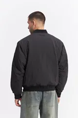 Campera tipo bomber de nylon color verde oliva, con cierre frontal, cuello, puños y cintura elastizados.